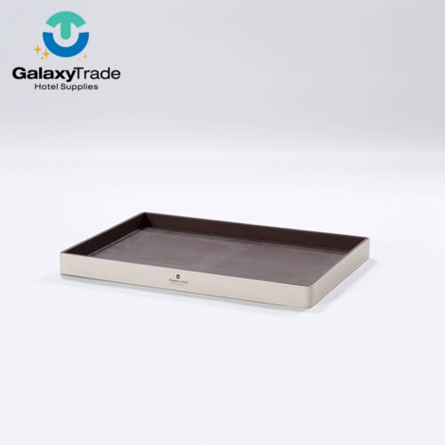 A Shangri-La branded luxury hotel service tray in beige faux leather with a shallow rectangular profile and dark wood-grain interior.