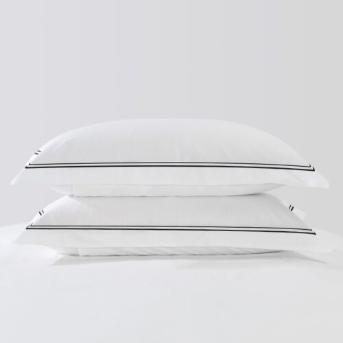 Luxury white hotel bedding set featuring a sharp black double-line embroidered border on the duvet and pillowcases.