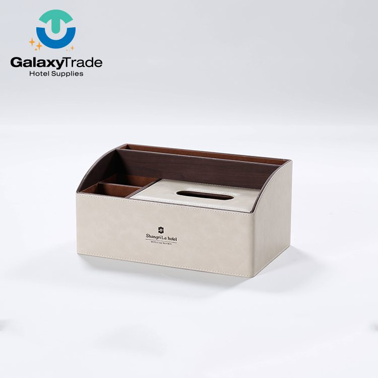 A Shangri-La branded luxury hotel multi-functional tissue box organizer in beige faux leather with dark wood-grain dividers.