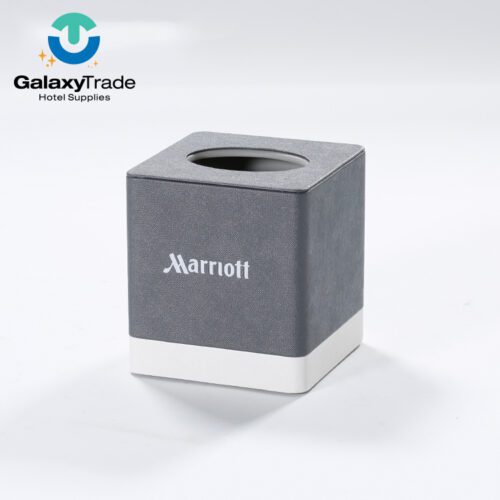 A Marriott Shanghai Luwan branded luxury hotel square tissue box cover in grey faux leather with a white base and top oval opening.