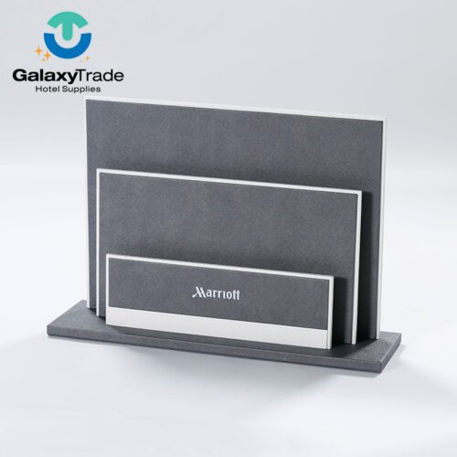 A Marriott Shanghai Luwan branded luxury hotel magazine rack in grey faux leather with white trim and a tiered three-pocket design.