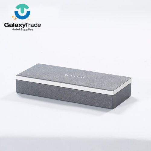 A Marriott Shanghai Luwan branded luxury hotel remote control box in grey faux leather with a white lid trim and slim rectangular profile.