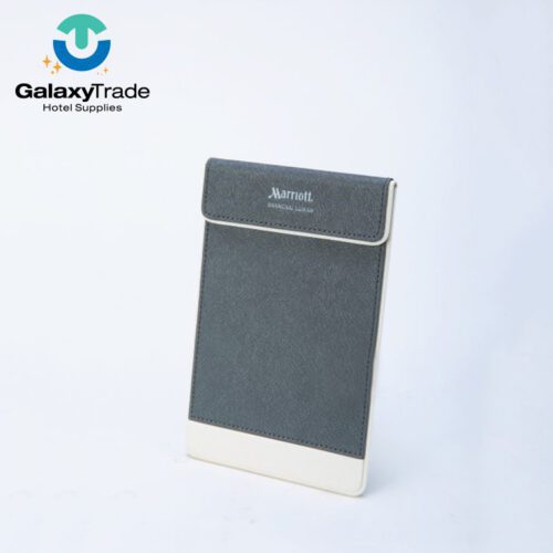 A Marriott Shanghai Luwan branded luxury hotel notepad holder in grey faux leather with a white base accent.