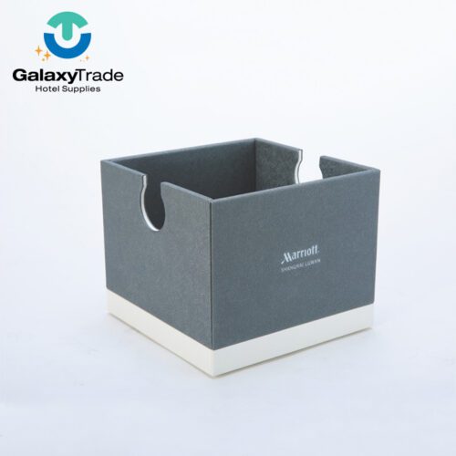 A Marriott Shanghai Luwan branded luxury hotel tissue box cover in grey faux leather with a white base and U-shaped side cutouts.