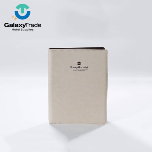 A Shangri-La branded luxury hotel A4 directory binder in beige faux leather with a dark wood-grain interior.