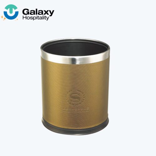 A professional shot of a cylindrical Gold Metallic Hotel Waste Basket featuring a textured gold body, a polished silver top rim, and an embossed laurel wreath logo.