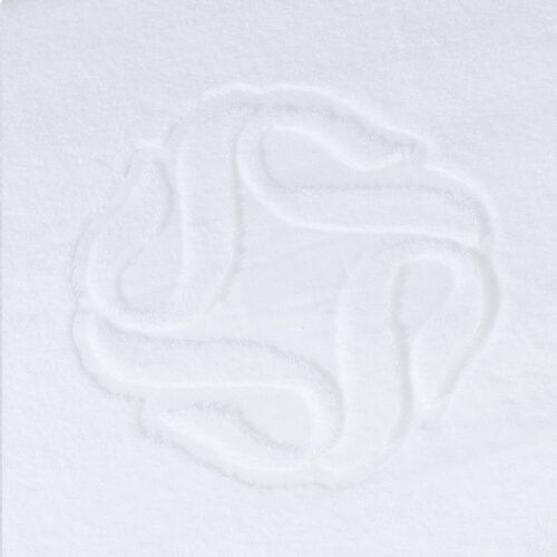 Close-up detail of a white cotton towel showcasing a meticulously woven, raised geometric motif of overlapping circular loops.