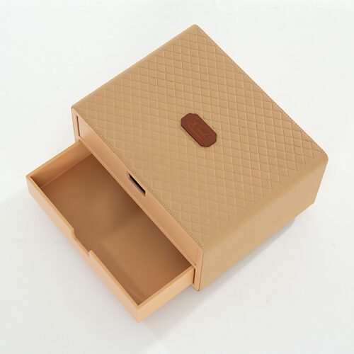 A professional product shot of a Kempinski branded beige faux leather coffee pod storage drawer with a diamond-patterned top.