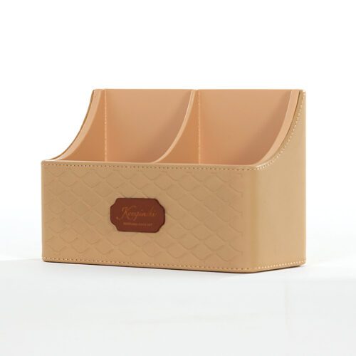 A professional product shot of a Kempinski branded beige faux leather remote control holder with two storage compartments.