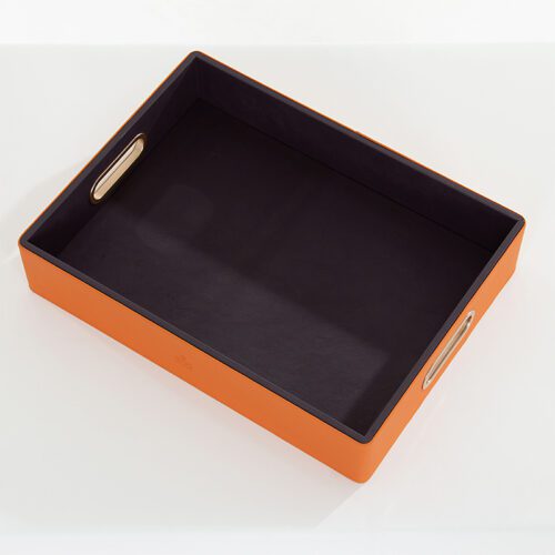 A Braira branded large rectangular vibrant orange faux leather service tray with deep purple interior and integrated gold oval handles.
