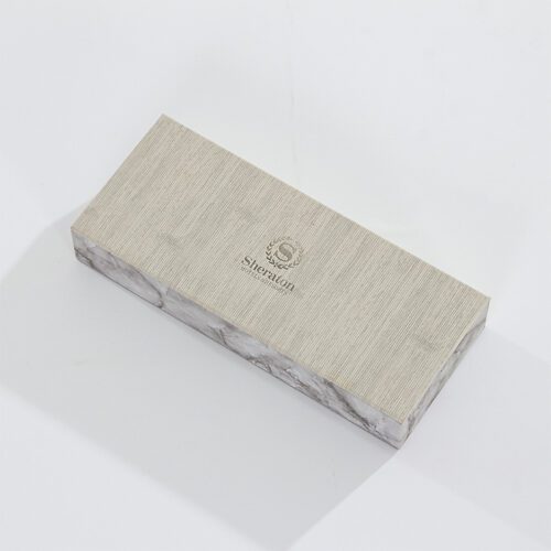 A Sheraton branded luxury hotel amenity tray featuring a grey linen-textured top and marble-patterned faux leather sides.