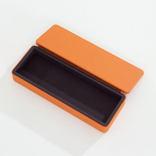 A Braira branded large rectangular vibrant orange faux leather tray with a deep purple interior and a debossed logo.