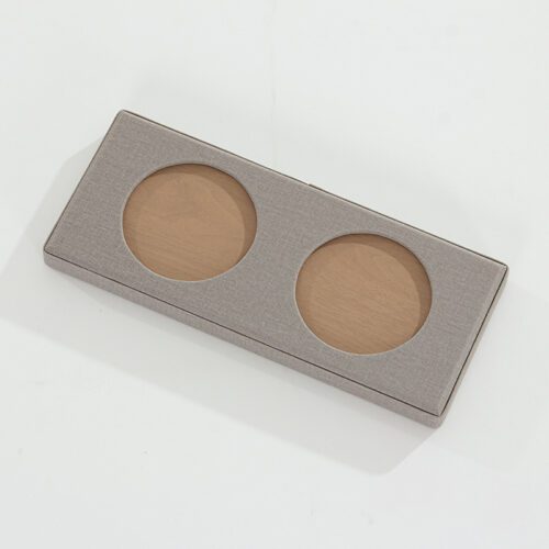 A Kempinski branded grey textured faux leather drinkware tray with two circular recessed slots and a tan interior base.