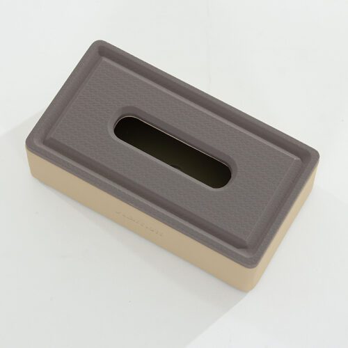 A top-down angled product shot of a Marriott branded rectangular beige and grey faux leather tissue box cover with a textured top.