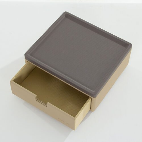 A front-facing product shot of a Marriott branded two-tone beige and grey faux leather single-drawer organizer unit with black non-slip feet.