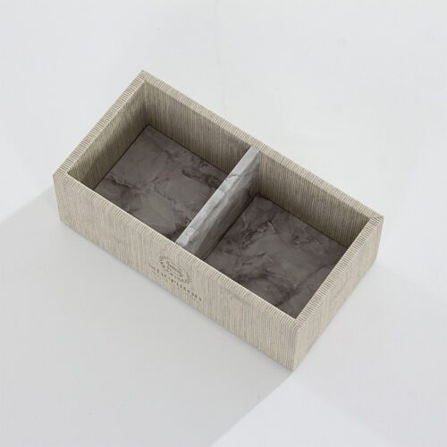 A Sheraton branded luxury hotel amenity organizer with a dual-compartment interior featuring grey marble patterns and a grey linen-textured leather exterior.