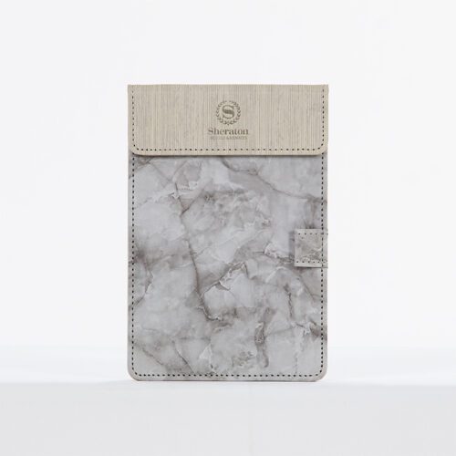 A Sheraton branded guest room folder featuring a grey marble-textured leather body and a cream top-stitched header.