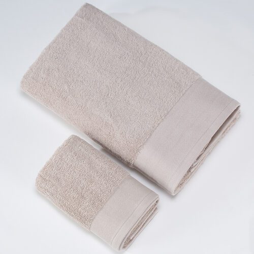 A stack of two folded oatmeal-beige plush cotton towels, including a bath towel and a hand towel, featuring wide satin borders.