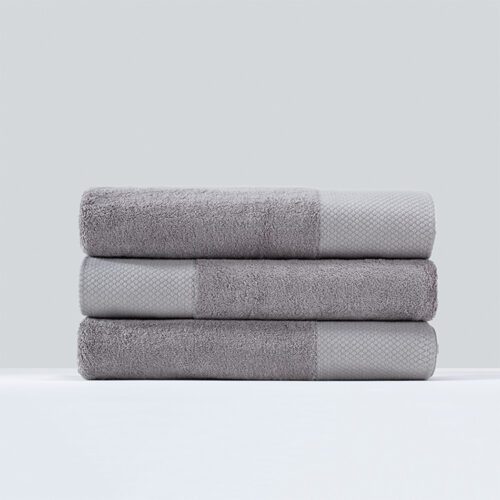 A stack of three neatly rolled grey plush cotton towels featuring a wide diamond-patterned textured border.