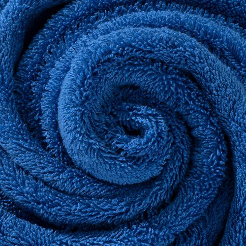 A full-length view of a plush royal blue bath towel featuring a small orange infinity logo embroidered at the bottom.