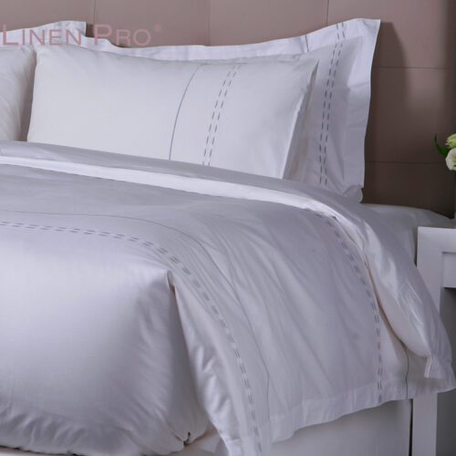 Luxury white hotel bedding set featuring a sophisticated grey interlocking weave embroidered border on the duvet and pillowcases.