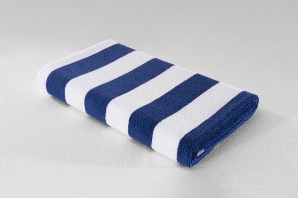 A neatly folded blue and white striped plush bath towel showing its thick cotton texture on a white surface.