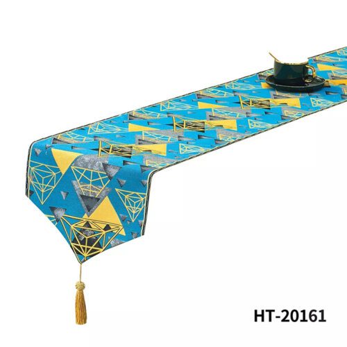 An azure blue bed runner with an abstract gold and grey geometric diamond pattern and a gold tassel.