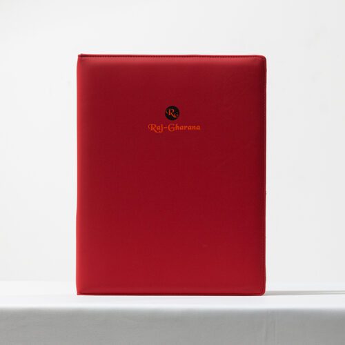 A professional product shot of a Raj-Gharana branded red matte leather folder for luxury hotel guest directories.