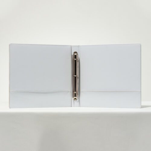 An open interior view of a Banyan Tree branded white leather 3-ring guest directory binder with metal rings and pockets.