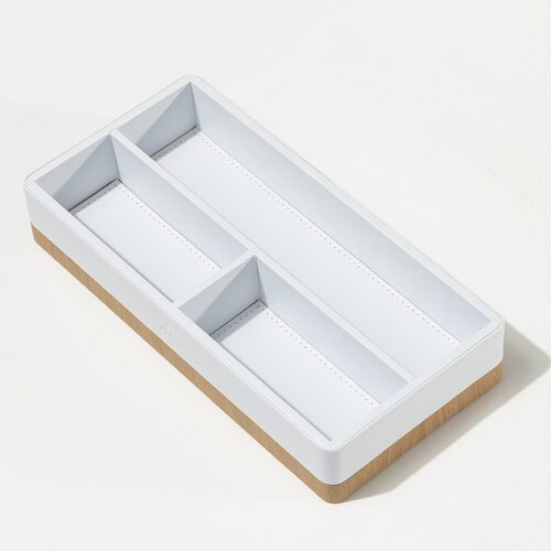 An overhead view of a Banyan Tree branded white leather and wood divided amenity tray for hotel guest rooms.