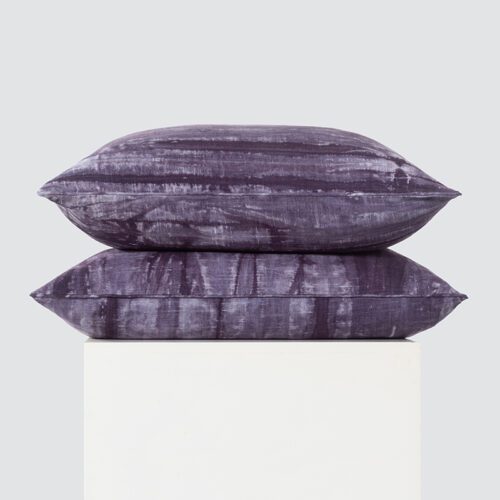 A high-resolution product shot of a stack of two Deep Plum Abstract Watercolor Pillows featuring a violet ethereal watercolor pattern and a smooth satin finish.