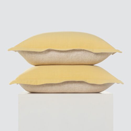 A high-resolution product shot of a stack of two Mustard Yellow and Natural Linen Flanged Pillows featuring a vibrant yellow top, natural linen bottom, and decorative flanged edges.