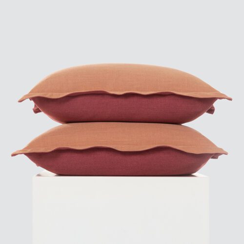 A high-resolution product shot of two Terracotta and Crimson Dual-Tone Flanged Pillows featuring a warm orange-red contrast and soft decorative flanged edges.