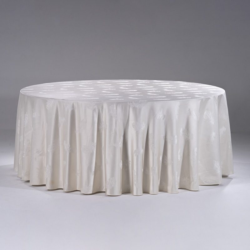 A large white round polyester tablecloth with an elegant feather jacquard pattern draped over a banquet table.