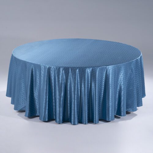 A large cerulean blue round polyester tablecloth with an elegant "Small Snowflake" jacquard pattern draped over a banquet table.