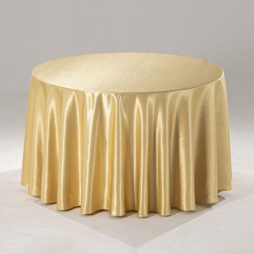 A large champagne-colored round polyester tablecloth with a subtle raindrop jacquard pattern draped over a banquet table in a professional setting.