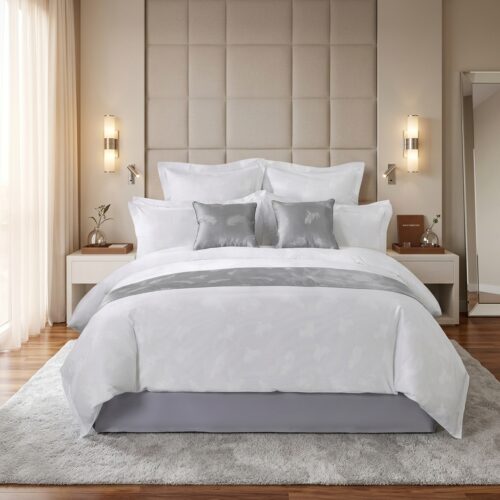 luxury white hotel bedding set with silver bed runner and decorative pillows in modern guest room