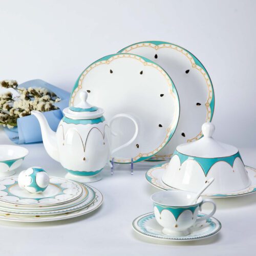 A comprehensive luxury porcelain dinnerware set featuring turquoise scalloped edges and gold detailing on a white bone china base.