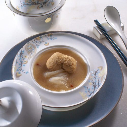A luxury porcelain soup tureen featuring a delicate blue and gold paisley floral pattern with a gold-rimmed lid and matching plate.