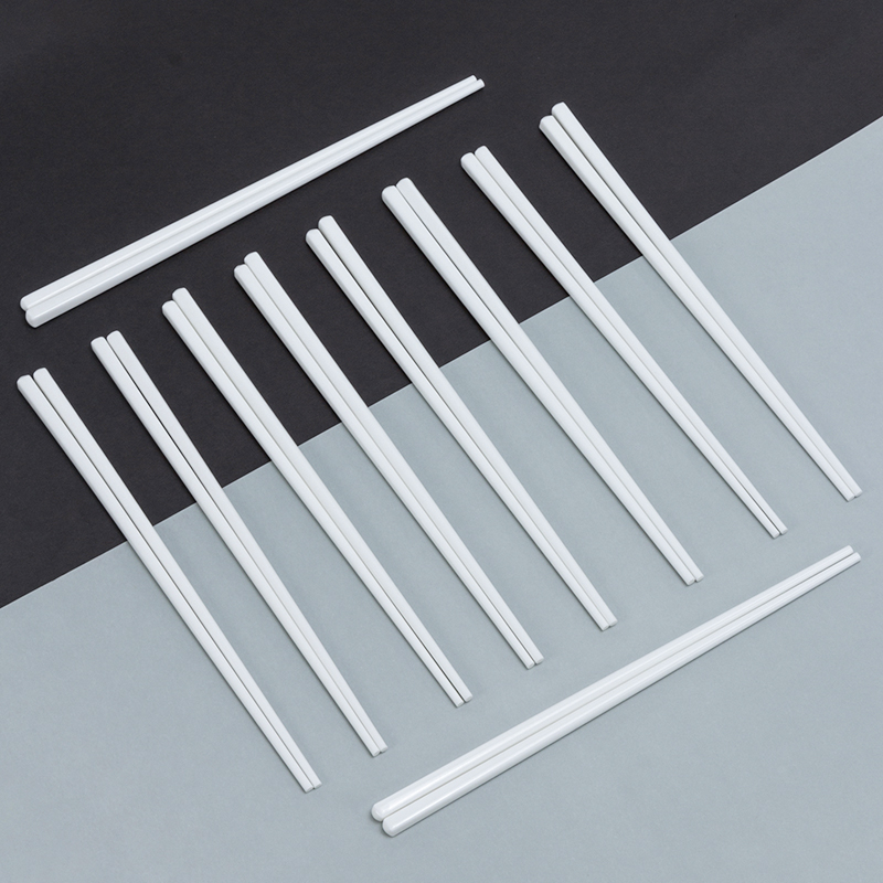 Galaxy white reusable porcelain ceramic chopsticks set neatly arranged on a modern black and light grey diagonal background.