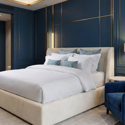 Luxury white hotel duvet cover and pillow sham set with teal jacquard accent cushions styled on a king bed with a cream upholstered frame against a deep navy blue and gold panel feature wall