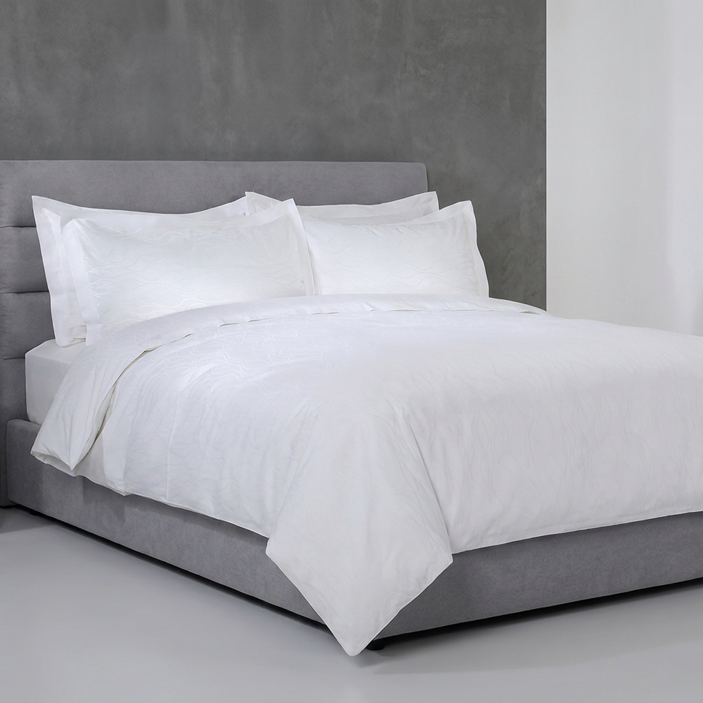 Luxury white minimalist hotel duvet cover set with large euro pillow shams styled on a king bed with a grey upholstered headboard and frame against a concrete grey feature wall