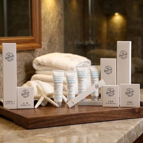 A comprehensive luxury hotel amenities set featuring branded white boxes and squeeze tubes arranged neatly on a dark wooden vanity tray.