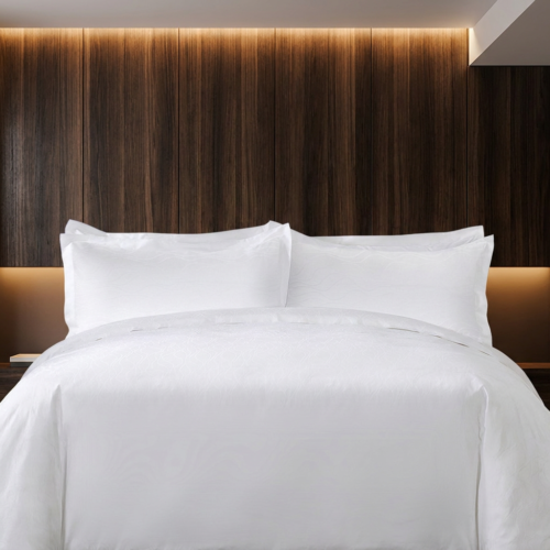 Premium white hotel sheets and crisp layered Oxford pillow shams styled against a dark vertical wood panel headboard background.