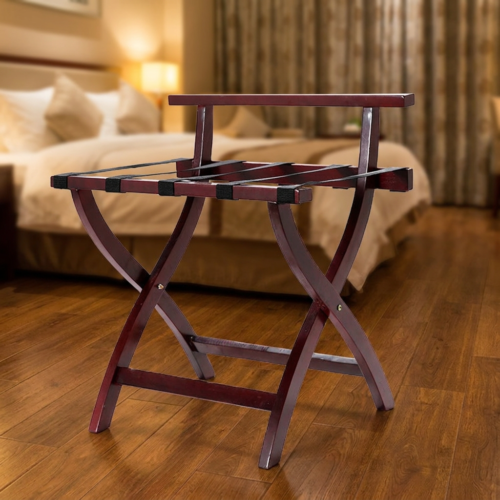 A luxury mahogany folding wooden hotel luggage rack with black nylon straps and a backrest bar displayed on a hardwood floor in a guest room.