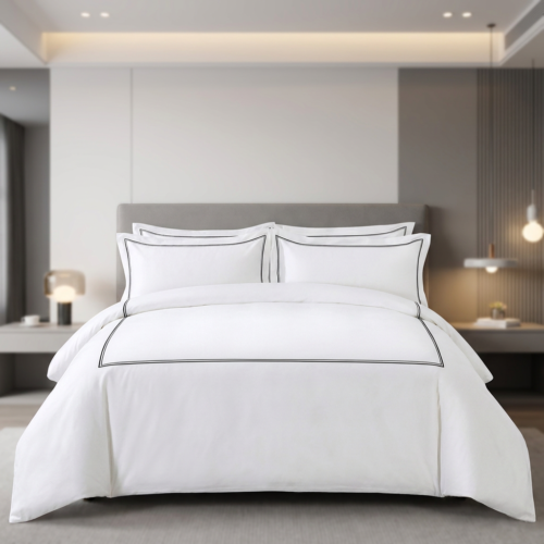 Galaxy premium white hotel duvet cover set with black embroidered double frame embroidery and matching Oxford pillowcases in a modern luxury guest suite.