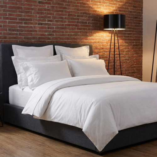 Galaxy premium crisp white hotel duvet cover set with layered Oxford pillowcases against a dark grey headboard and exposed red brick accent wall.