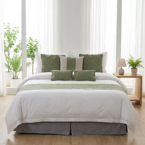 Galaxy premium white hotel duvet cover layered with textured sage green speckled Euro shams, accent pillows, bed runner, and a grey bed skirt in a sunlit eco-resort suite.