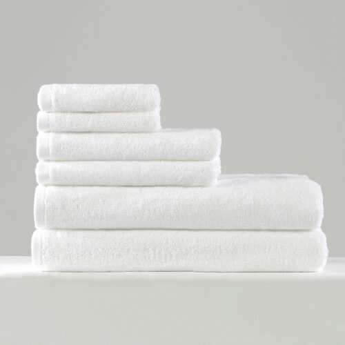 Stacked set of six plain white 100% cotton hotel towels with neat diagonal hem borders.