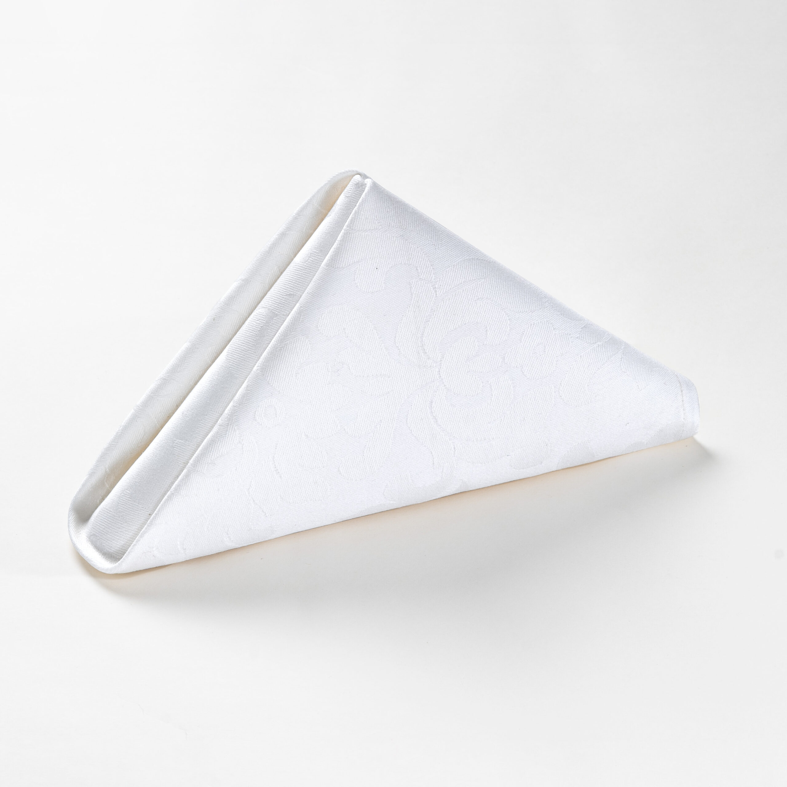 Galaxy premium white floral jacquard polyester cloth napkin folded in a standing pyramid shape on a clean white background.